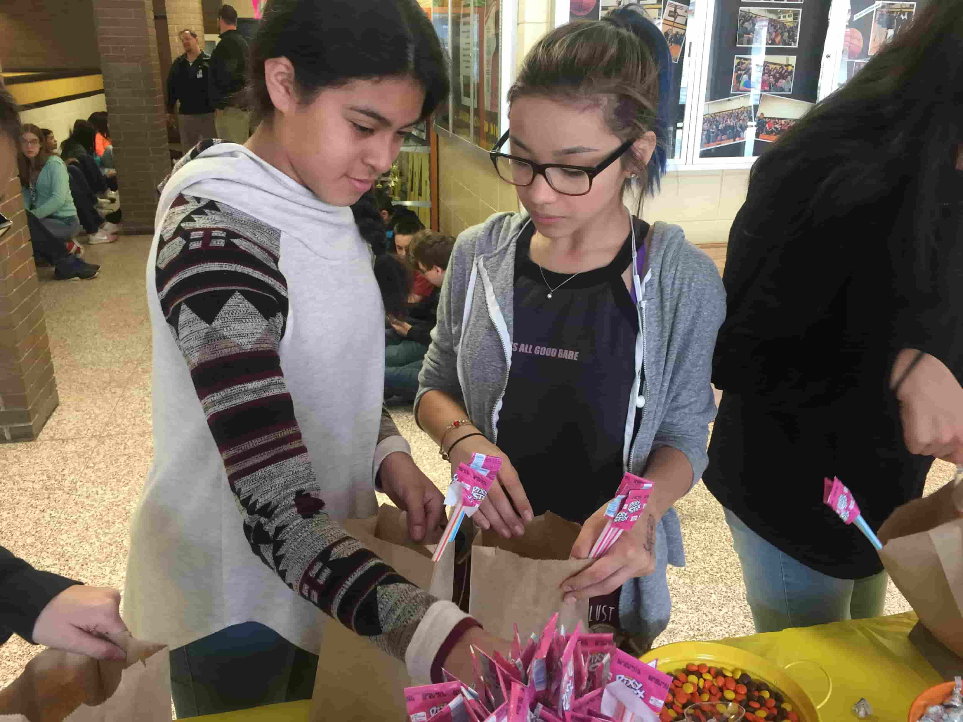 Two students fill up their bags at the PBIS store