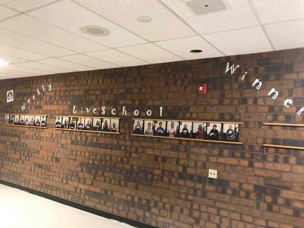 A wall of a hallway showing "Weekly LiveSchool Winners" with pictures of students below