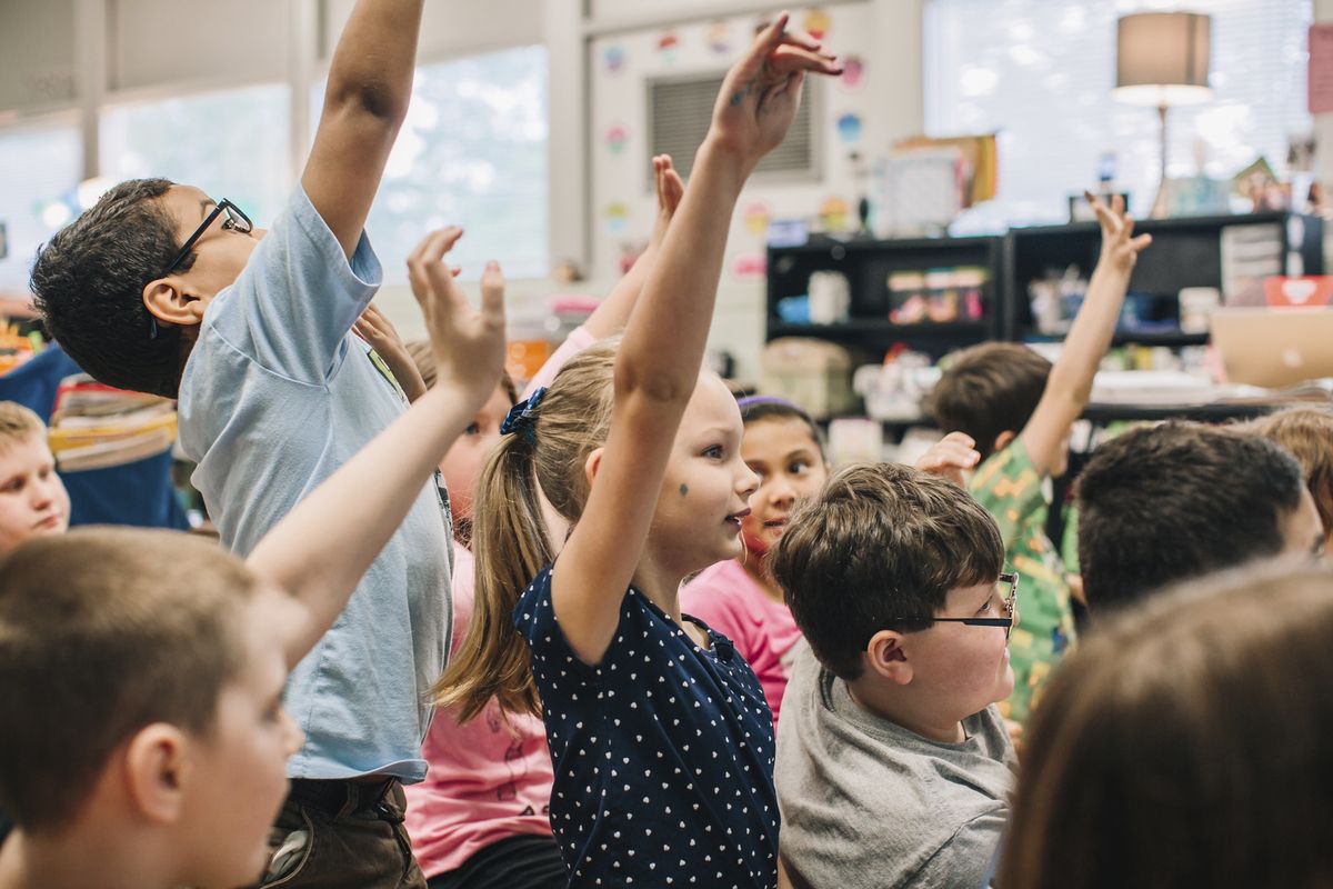 Students raising their hands enthusiastically