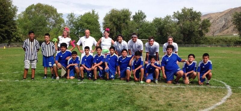 7 Faculty and 11 Students Pose on a Soccer Field during a Student/Faculty soccer game, with 2 student referees